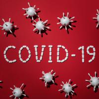 Covid 19 på rød baggrund med små virus